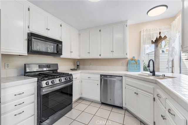 42851 Lemonwood Dr, Lancaster, CA 93536 - kitchen featuring stainless steel appliances, tile countertops, white cabinets, and light tile patterned floors