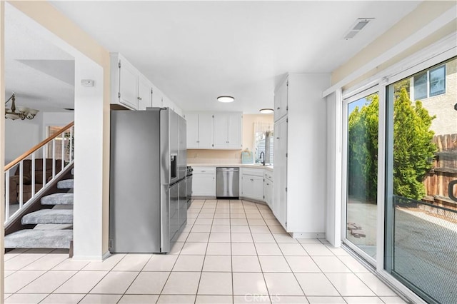 42851 Lemonwood Dr, Lancaster, CA 93536 - kitchen featuring appliances with stainless steel finishes, light countertops, white cabinetry, and light tile patterned flooring