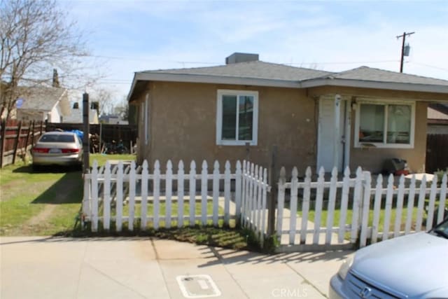 241 Hull Ave, Madera, CA 93638 - bungalow-style home with a fenced front yard, a shingled roof, and stucco siding