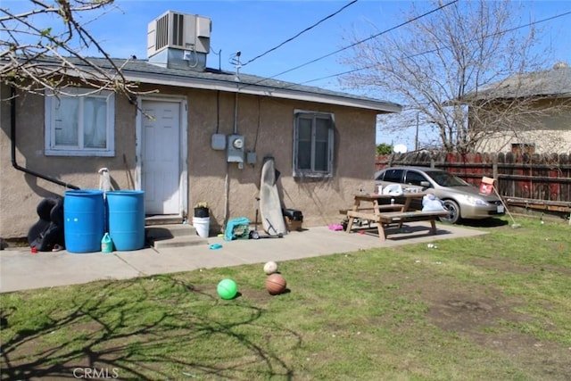 241 Hull Ave, Madera, CA 93638 - rear view of house with fence, entry steps, central AC, stucco siding, and a yard
