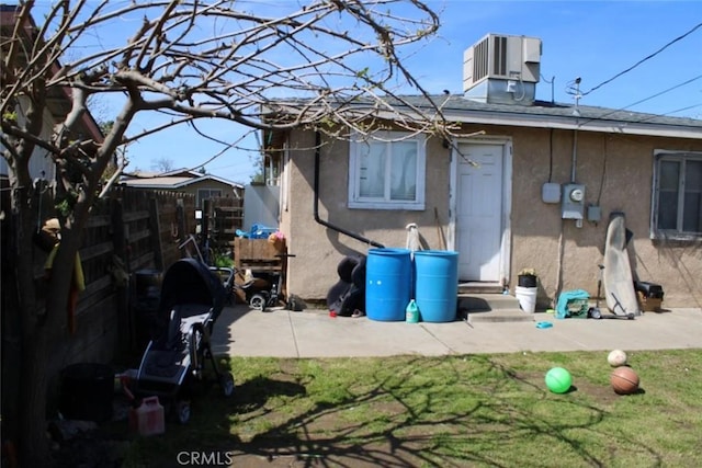 241 Hull Ave, Madera, CA 93638 - back of property featuring central AC unit, stucco siding, entry steps, fence private yard, and a lawn