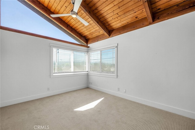 empty room featuring a ceiling fan, carpet, wooden ceiling, baseboards, and vaulted ceiling with beams