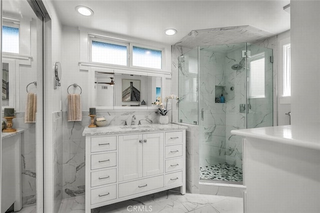 bathroom with a marble finish shower, recessed lighting, marble finish floor, and vanity