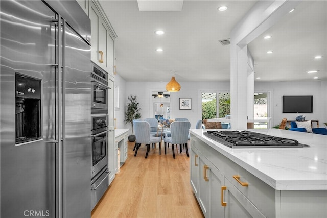 kitchen featuring a warming drawer, light wood-type flooring, visible vents, gray cabinets, and stainless steel appliances