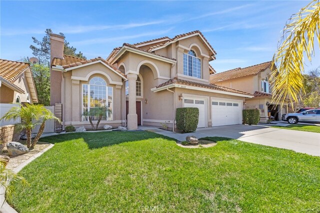 mediterranean / spanish house with a tiled roof, a chimney, driveway, and stucco siding