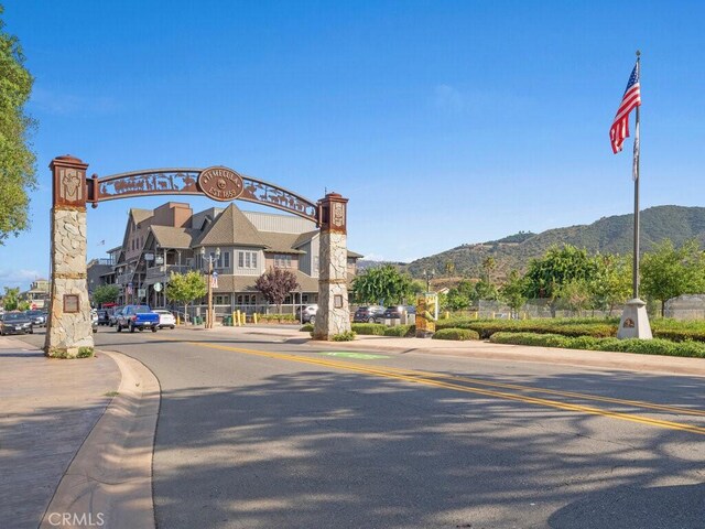 view of road with curbs, a mountain view, and sidewalks