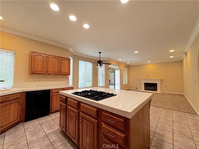 kitchen featuring tile countertops, light tile patterned floors, a fireplace with raised hearth, black appliances, and recessed lighting