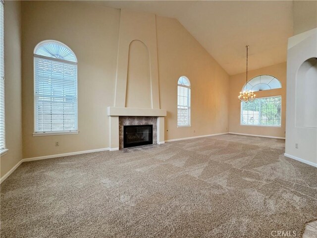 unfurnished living room featuring carpet flooring, a chandelier, and a wealth of natural light