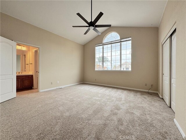 unfurnished bedroom with baseboards, light colored carpet, lofted ceiling, and a closet