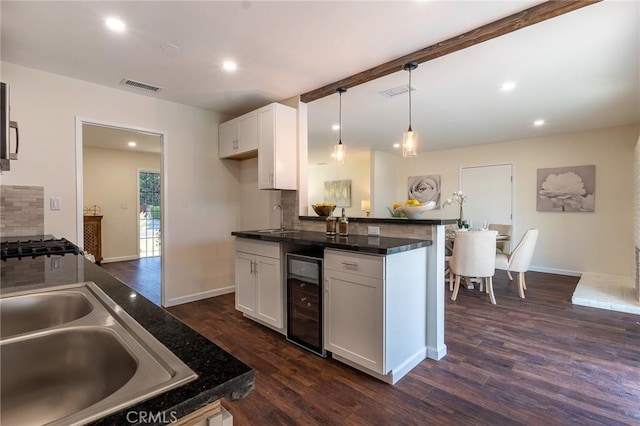 kitchen with visible vents, white cabinets, dark countertops, dark wood finished floors, and wine cooler