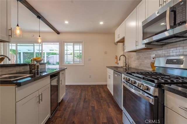 kitchen with stainless steel appliances, a wealth of natural light, a sink, and decorative backsplash