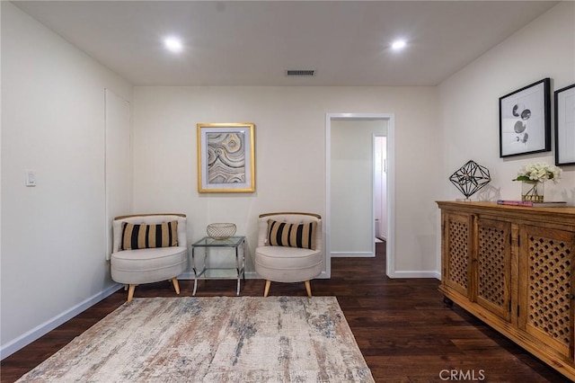 living area featuring visible vents, baseboards, recessed lighting, and dark wood-style floors