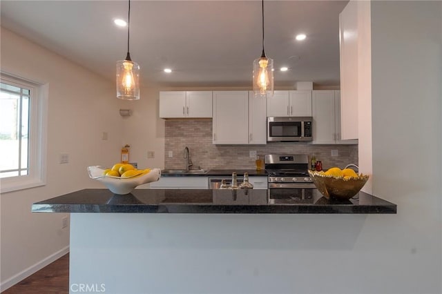 kitchen featuring a sink, backsplash, white cabinetry, and stainless steel appliances