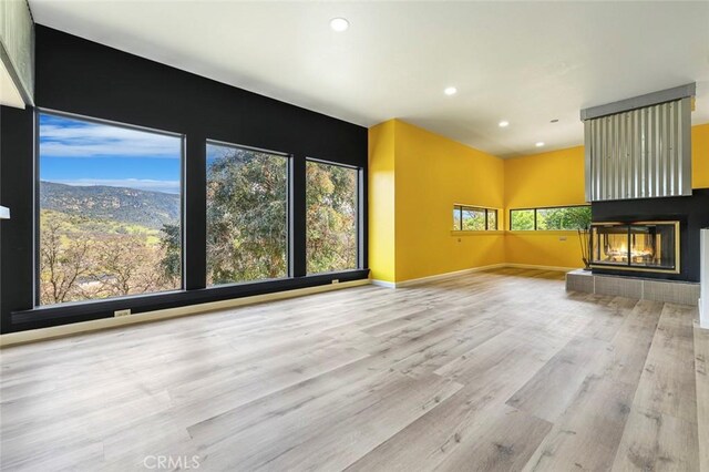 28951 Spring Valley Rd, Tollhouse, CA 93667 - unfurnished living room with recessed lighting, wood finished floors, a multi sided fireplace, and baseboards