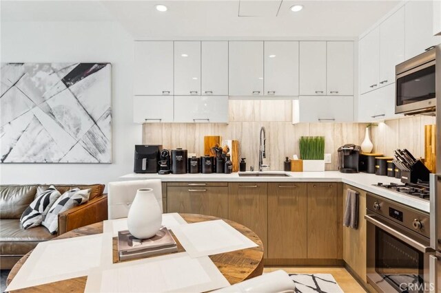 400 S Broadway Unit 1011, Los Angeles, CA 90013 - kitchen featuring stainless steel appliances, a sink, modern cabinets, white cabinetry, and light countertops