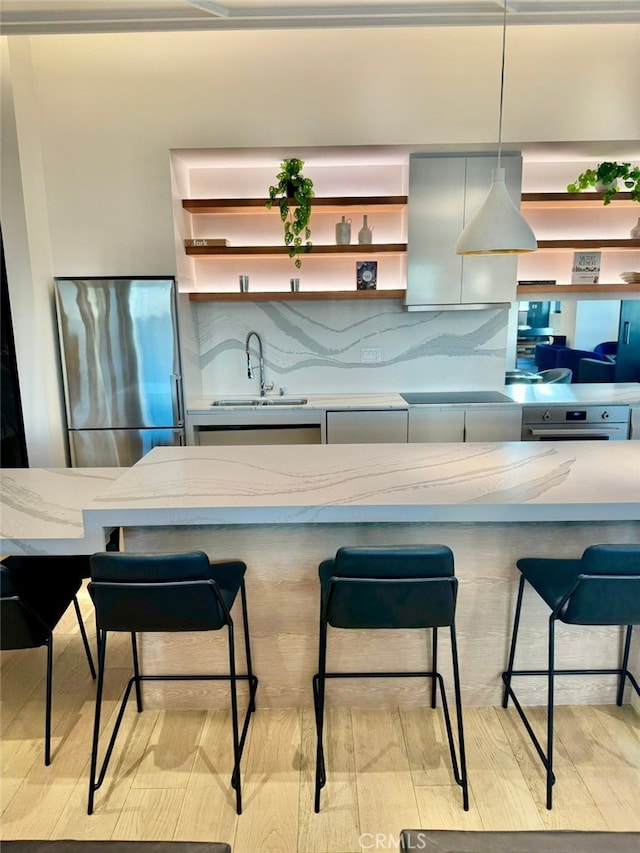 400 S Broadway Unit 1011, Los Angeles, CA 90013 - kitchen with stainless steel fridge, a sink, open shelves, light stone counters, and decorative backsplash