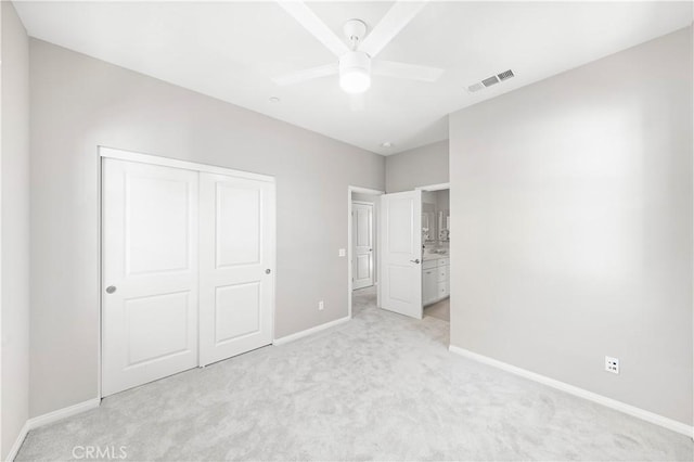 unfurnished bedroom with visible vents, baseboards, light colored carpet, and a closet