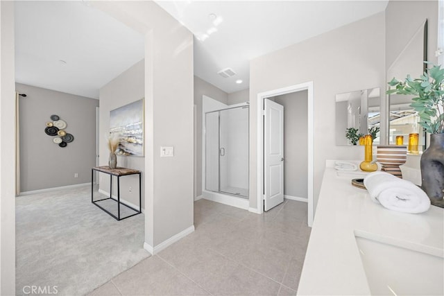 corridor featuring visible vents, carpet, baseboards, tile patterned floors, and a sink