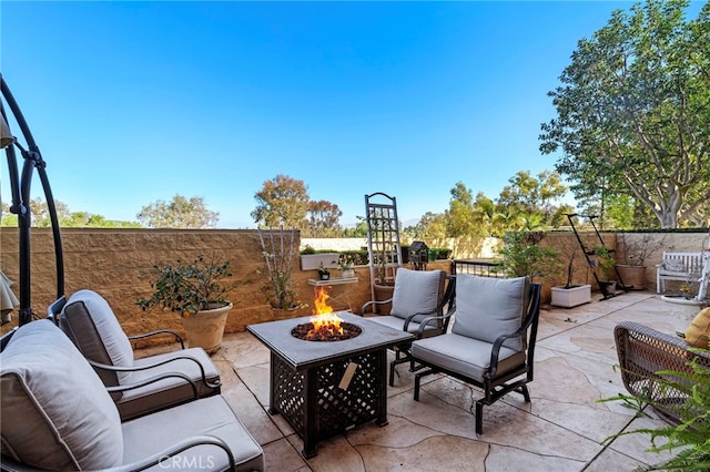 view of patio / terrace with an outdoor fire pit and fence