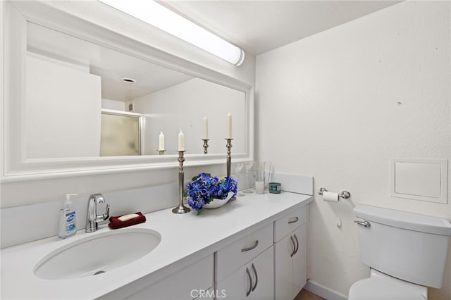 full bath featuring toilet, vanity, and a shower stall