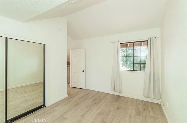 712 E Magill Ave, Fresno, CA 93710 - unfurnished bedroom with light wood-style flooring, vaulted ceiling, and a closet