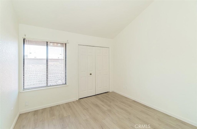 712 E Magill Ave, Fresno, CA 93710 - unfurnished bedroom with light wood-style floors, a closet, and vaulted ceiling