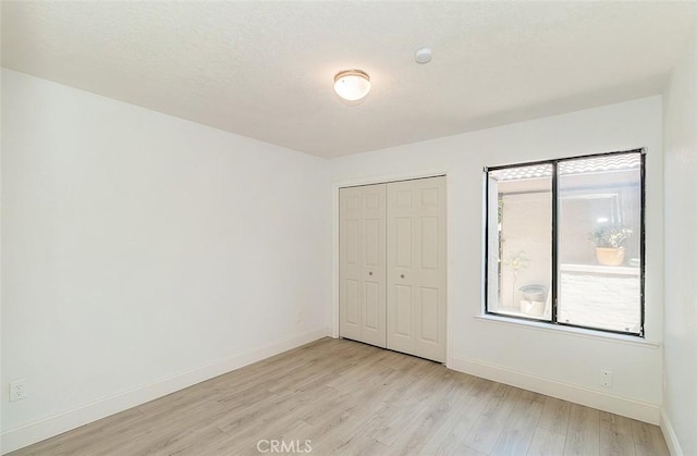 712 E Magill Ave, Fresno, CA 93710 - unfurnished bedroom with light wood-style flooring and a closet