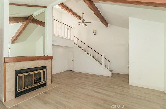 712 E Magill Ave, Fresno, CA 93710 - unfurnished living room featuring stairs, beamed ceiling, a ceiling fan, a fireplace, and wood finished floors