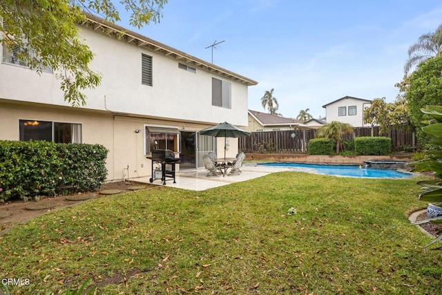 rear view of property with stucco siding, a patio, a fenced backyard, a yard, and a fenced in pool