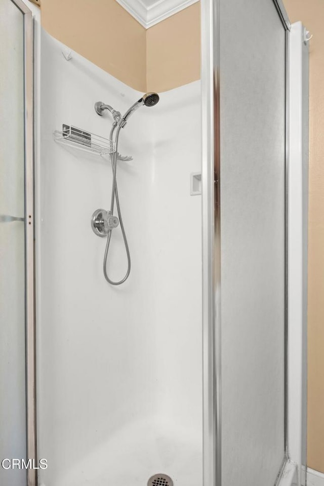 full bath featuring a stall shower and crown molding
