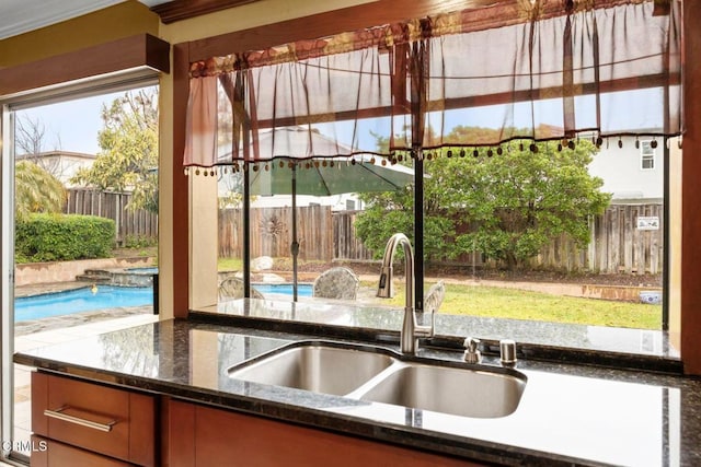 kitchen featuring dark stone countertops and a sink