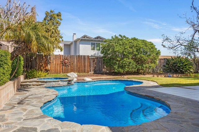 view of swimming pool with a patio area, a fenced backyard, and a pool with connected hot tub