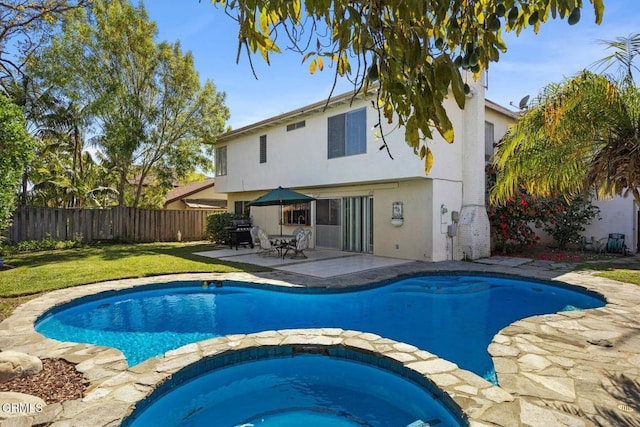 view of pool with a fenced backyard, a pool with connected hot tub, a patio area, a lawn, and a grill