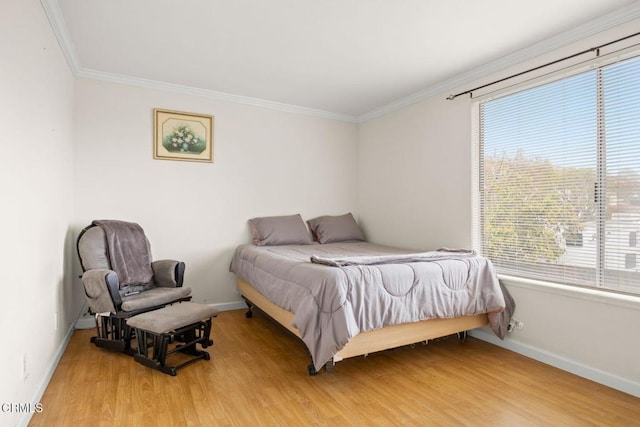 bedroom featuring light wood finished floors, multiple windows, baseboards, and ornamental molding