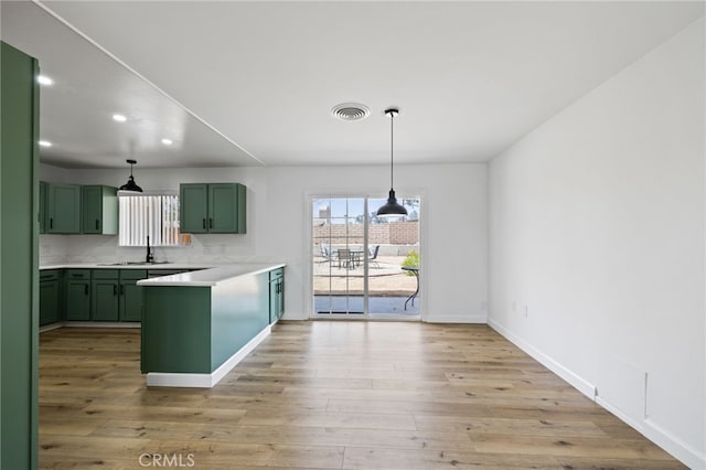 43415 Illinois Ave, Palm Desert, CA 92211 - kitchen featuring green cabinets, a peninsula, light countertops, hanging light fixtures, and recessed lighting