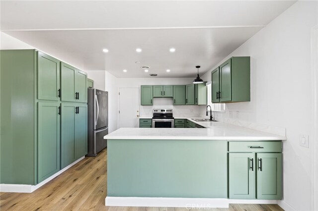 43415 Illinois Ave, Palm Desert, CA 92211 - kitchen with appliances with stainless steel finishes, green cabinets, a sink, a peninsula, and light wood-style floors