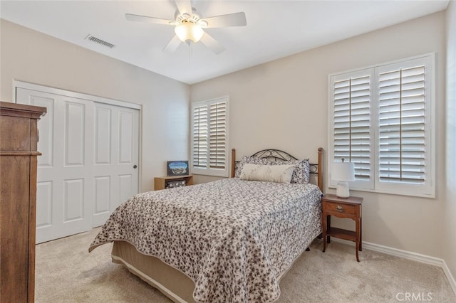 carpeted bedroom with baseboards, a ceiling fan, a closet, and visible vents