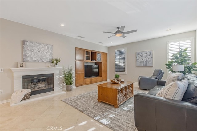 living area with visible vents, a glass covered fireplace, ceiling fan, recessed lighting, and light tile patterned floors