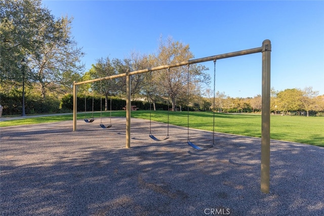 view of property's community with a lawn and playground community