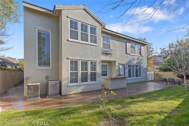 rear view of house with stucco siding, a patio area, and central air condition unit