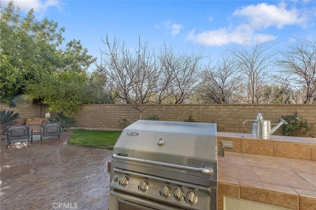 view of patio with a fenced backyard and a grill