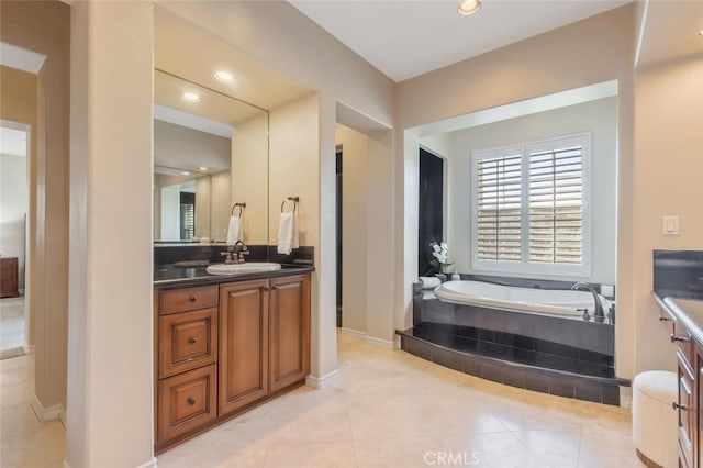 bathroom featuring vanity, recessed lighting, and a bath