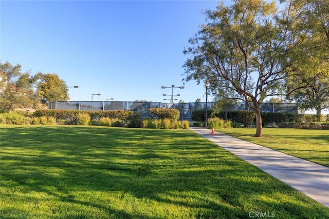 view of property's community with fence and a yard