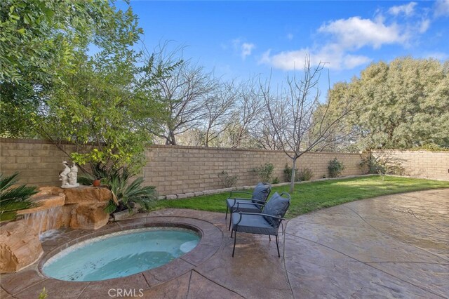 view of pool with a fenced backyard, an in ground hot tub, a lawn, and a patio area