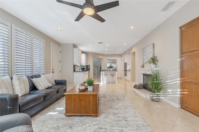 living area featuring ceiling fan, recessed lighting, baseboards, light tile patterned floors, and visible vents