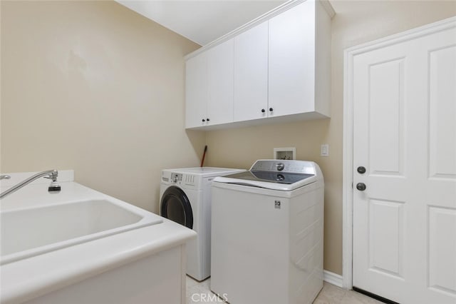 laundry area with a sink, independent washer and dryer, and cabinet space