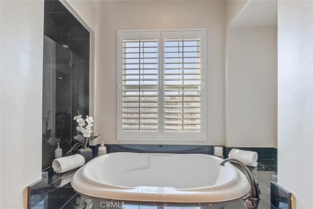 full bath with a shower and a bath