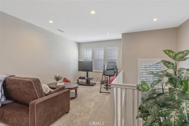 living area featuring recessed lighting, baseboards, visible vents, and light carpet