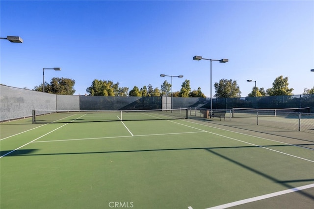 view of tennis court with fence and community basketball court