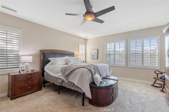 bedroom featuring baseboards, a ceiling fan, light colored carpet, and visible vents